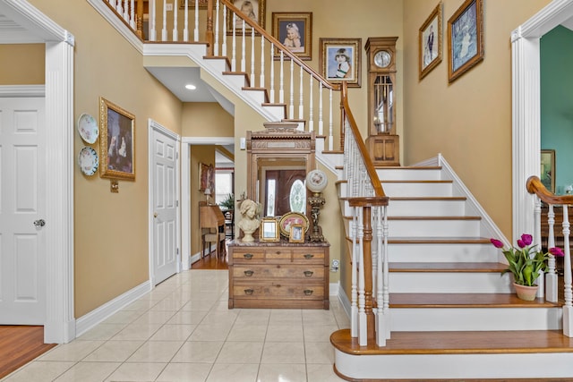 stairway featuring tile patterned flooring and a high ceiling