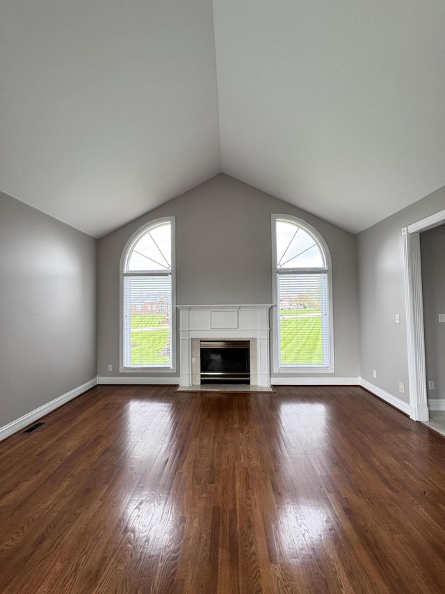 unfurnished living room with vaulted ceiling, visible vents, wood finished floors, baseboards, and a fireplace