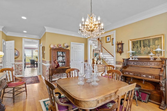 dining room featuring an inviting chandelier, ornamental molding, and light hardwood / wood-style floors