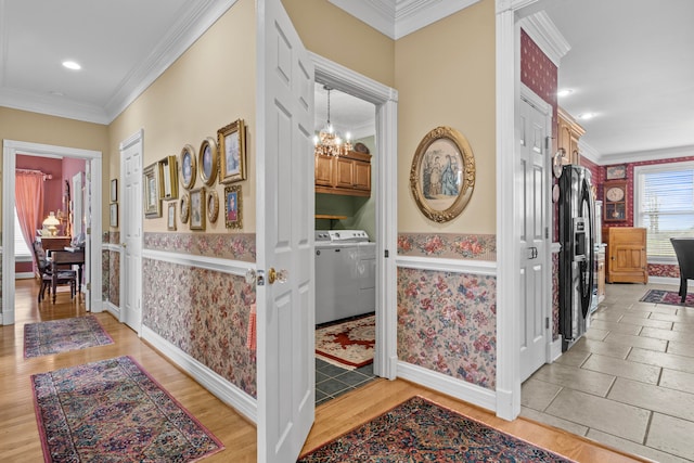 hall featuring ornamental molding, light hardwood / wood-style flooring, and a notable chandelier