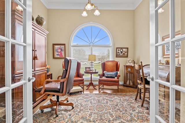 living area featuring french doors, crown molding, hardwood / wood-style floors, and a notable chandelier