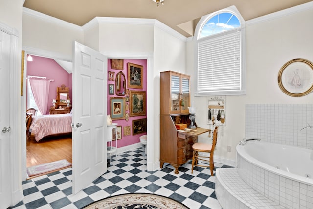 bathroom with crown molding, tiled bath, toilet, and a wealth of natural light