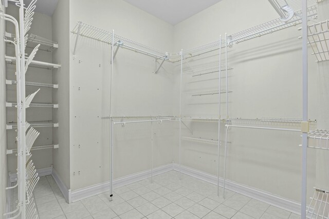 laundry area with dark tile patterned floors, washing machine and dryer, cabinets, ornamental molding, and a chandelier