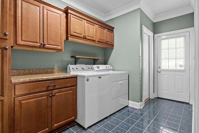 washroom with washer and clothes dryer, baseboards, cabinet space, crown molding, and dark tile patterned floors