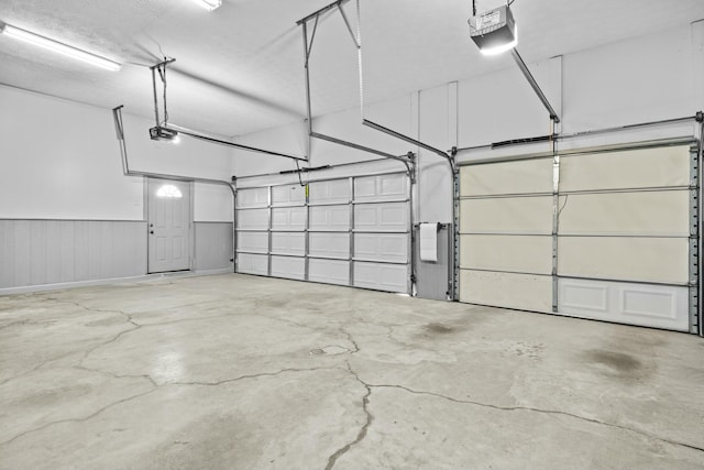 garage featuring a wainscoted wall and a garage door opener