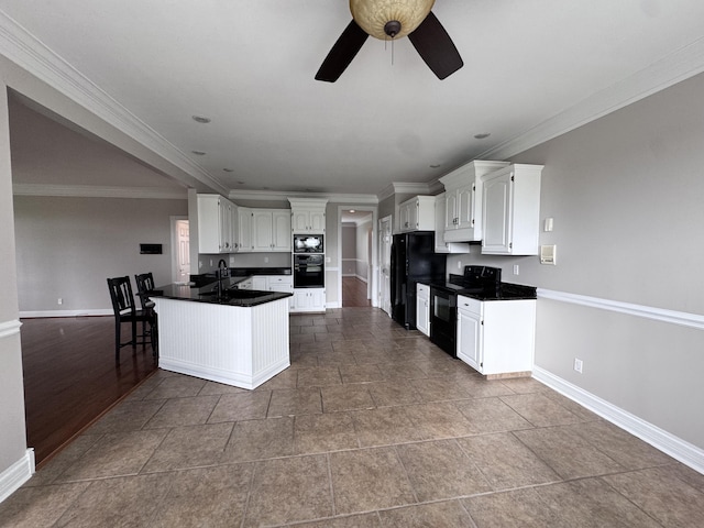 kitchen with black appliances, baseboards, white cabinets, a peninsula, and ornamental molding
