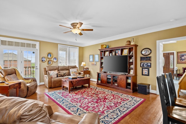 living room featuring crown molding, ceiling fan, and light wood-type flooring