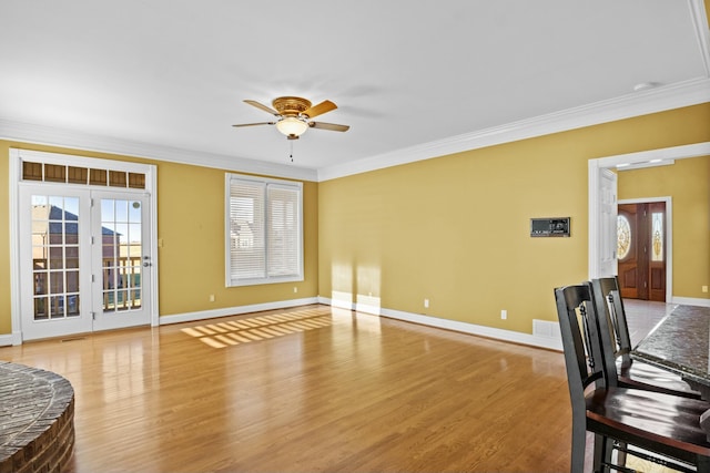 interior space with wood finished floors, a healthy amount of sunlight, crown molding, and ceiling fan