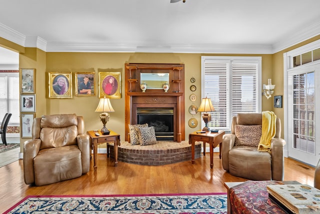 living room with ornamental molding, a fireplace, and hardwood / wood-style floors