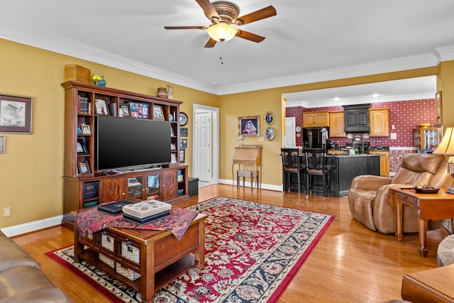 living room featuring ornamental molding, ceiling fan, and light hardwood / wood-style floors