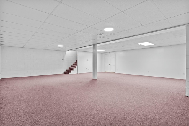 finished below grade area featuring carpet flooring, stairway, and a drop ceiling