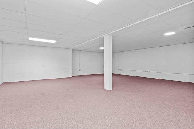 finished basement featuring concrete block wall, carpet floors, and a drop ceiling