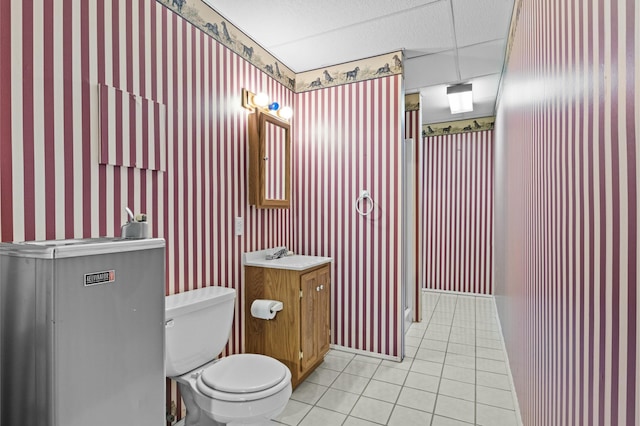 bathroom with tile patterned floors, vanity, wallpapered walls, and toilet