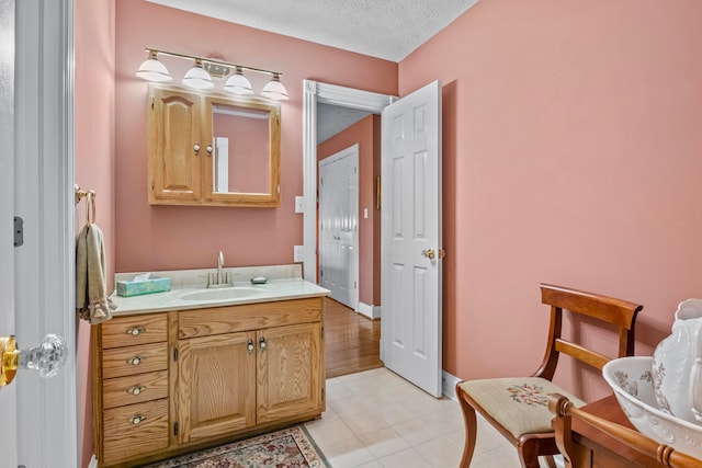 bathroom featuring vanity, tile patterned flooring, and a textured ceiling