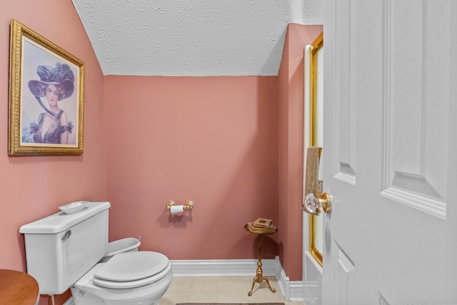 bathroom with lofted ceiling, tile patterned floors, a textured ceiling, and toilet