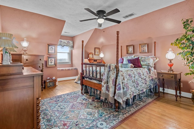 bedroom featuring light hardwood / wood-style floors and a textured ceiling