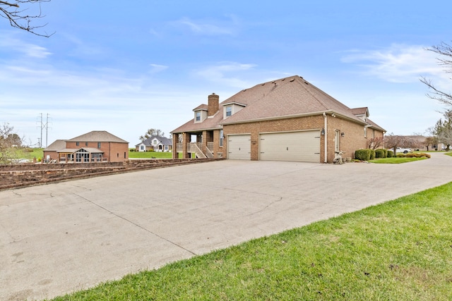 exterior space featuring a garage and a lawn