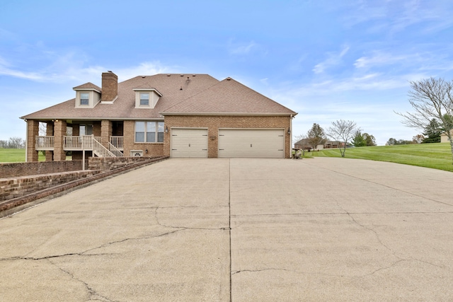 view of front of house with a garage, a front lawn, and a porch