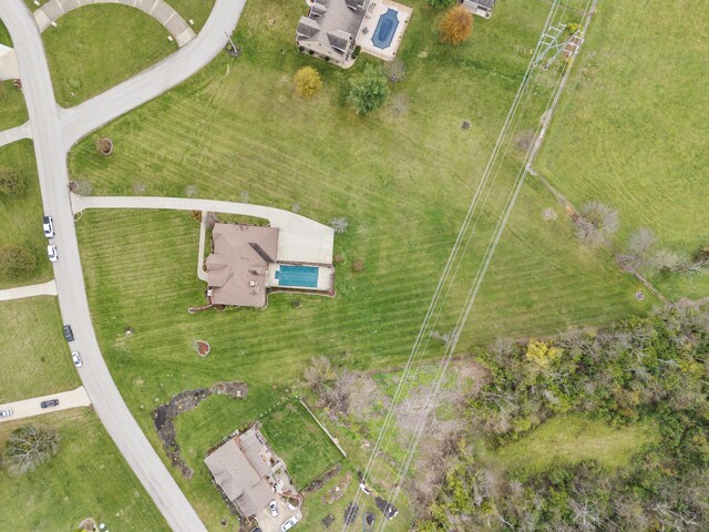 rear view of property featuring a balcony, a garage, and a lawn