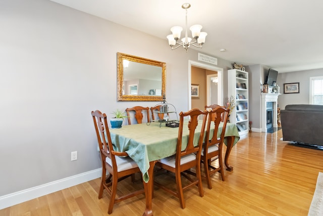 dining area featuring wood-type flooring and a notable chandelier