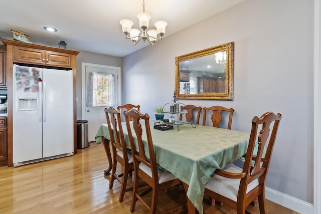 dining area with a chandelier and light hardwood / wood-style flooring