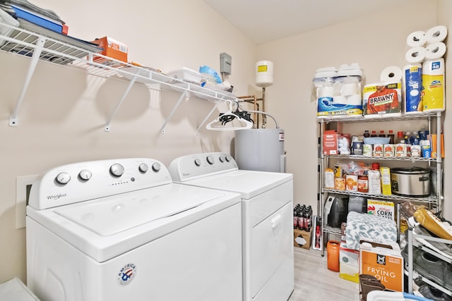 washroom with electric water heater, light hardwood / wood-style floors, and separate washer and dryer