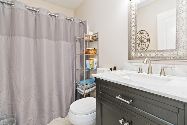 bathroom with toilet, vanity, and tile patterned flooring