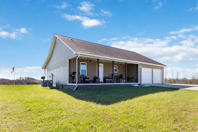 exterior space featuring a front lawn, ceiling fan, covered porch, and a garage