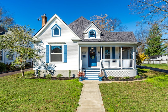 bungalow-style home with a front yard and covered porch