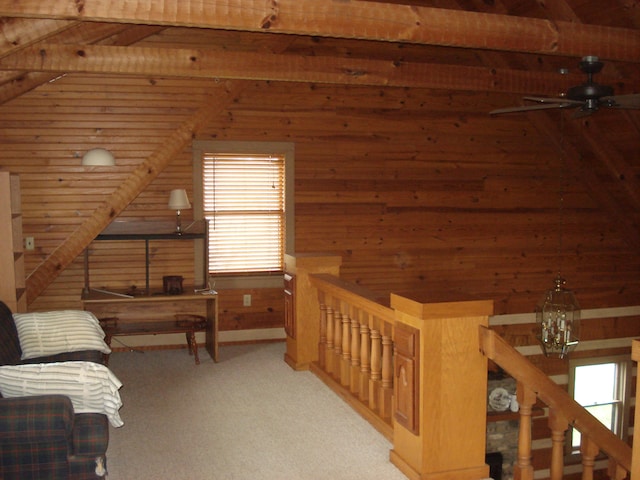 living area with lofted ceiling with beams, light colored carpet, wooden walls, and wood ceiling