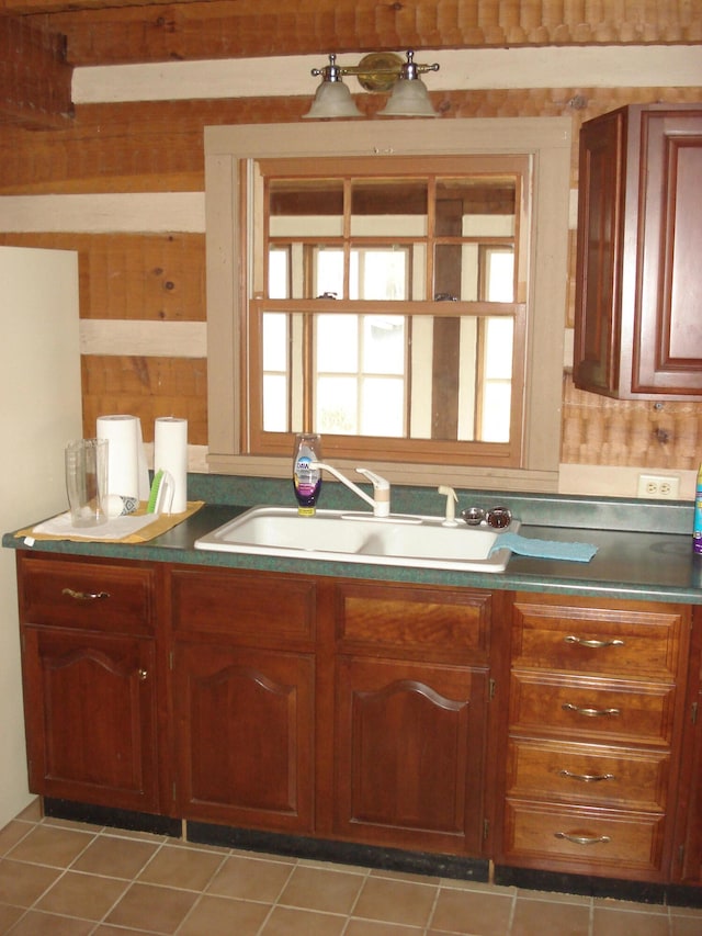 kitchen featuring light tile patterned floors and sink