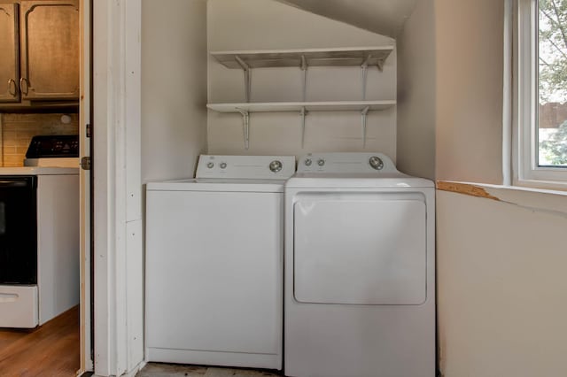 laundry room with washing machine and dryer and light hardwood / wood-style floors