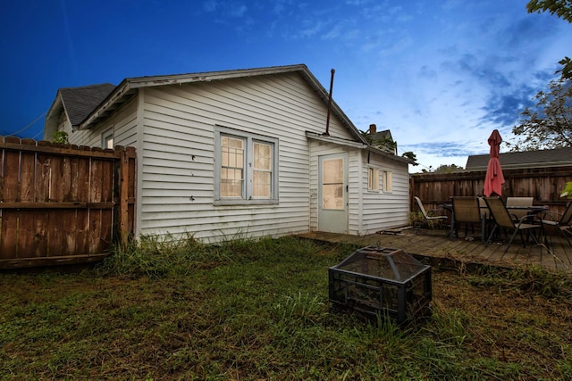 back of property featuring a wooden deck and an outdoor fire pit