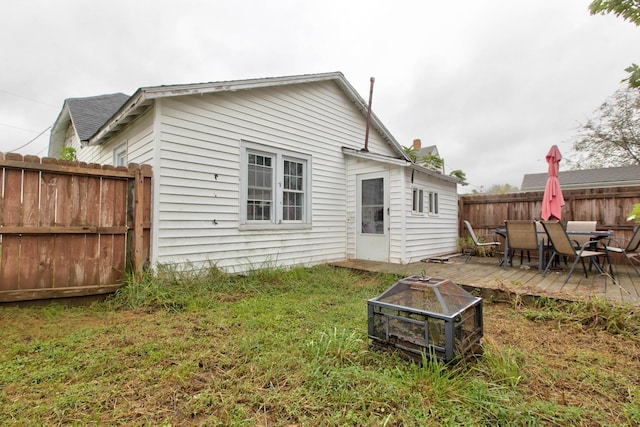 back of house featuring a lawn and a wooden deck