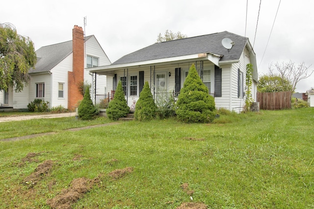 view of front of home with a porch, cooling unit, and a front yard