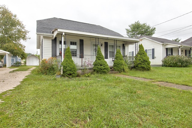 view of front facade featuring a porch, a front lawn, and an outdoor structure