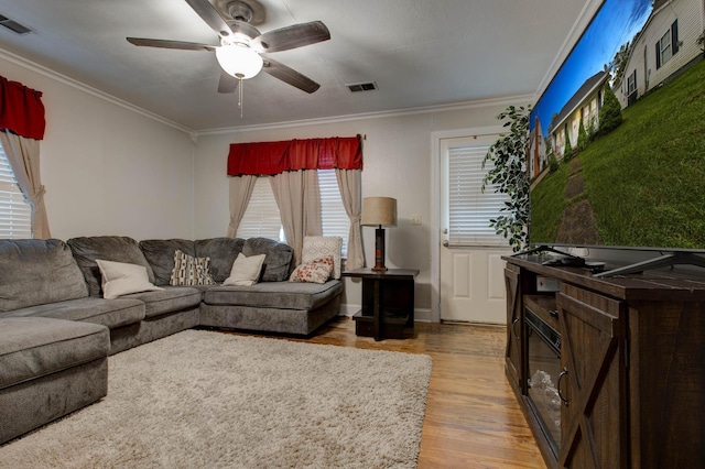 living room with ornamental molding, hardwood / wood-style flooring, and ceiling fan