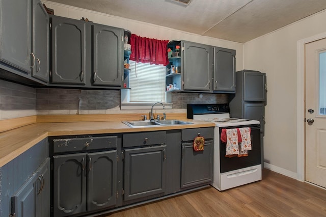 kitchen with wooden counters, electric stove, light wood-type flooring, sink, and decorative backsplash