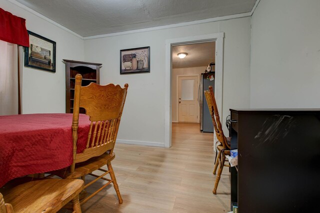 dining space with a textured ceiling and light hardwood / wood-style floors