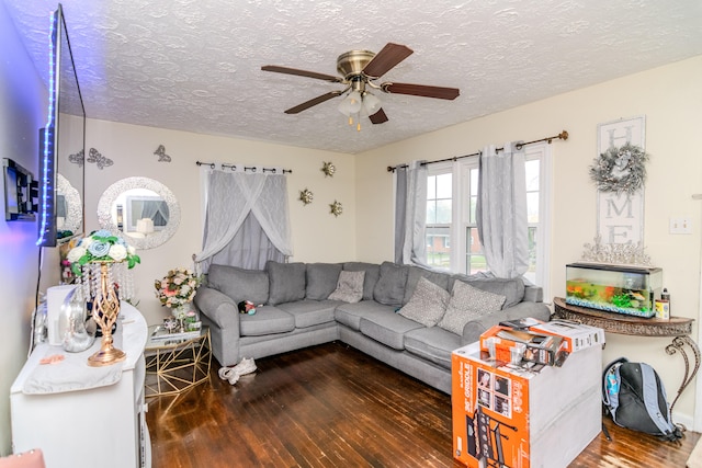 living room with a textured ceiling, ceiling fan, and dark wood-type flooring