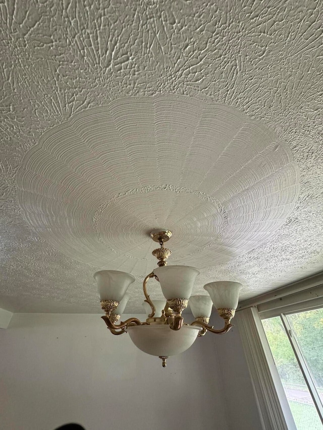 details with a textured ceiling and an inviting chandelier