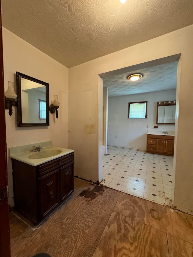 bathroom featuring tile patterned flooring, vanity, and a textured ceiling