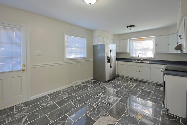 kitchen featuring white cabinets, stainless steel refrigerator with ice dispenser, and sink