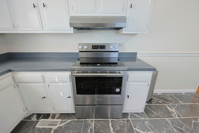 kitchen featuring wall chimney range hood, white cabinets, and stainless steel electric stove