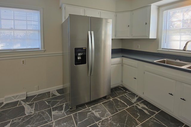 kitchen featuring sink, stainless steel fridge with ice dispenser, and white cabinets