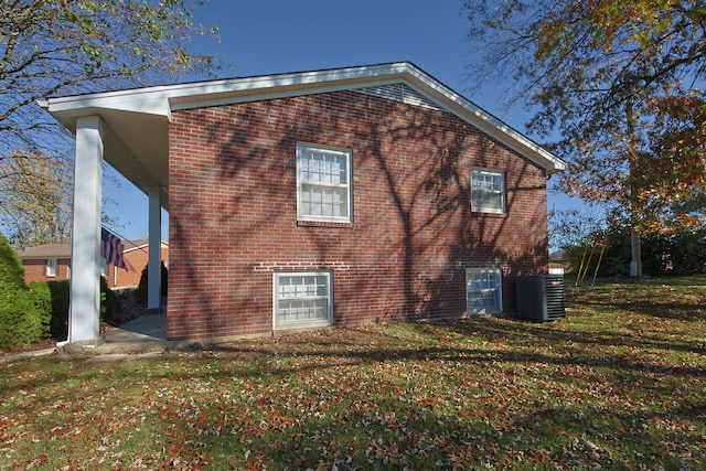 rear view of property featuring a yard and cooling unit