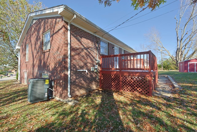 view of side of property with central air condition unit, a lawn, a storage shed, and a wooden deck