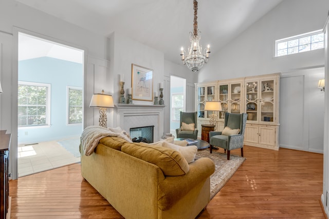 living room featuring light wood-type flooring, a wealth of natural light, and vaulted ceiling