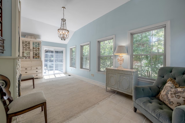 sitting room with light tile patterned flooring, a wealth of natural light, an inviting chandelier, and vaulted ceiling