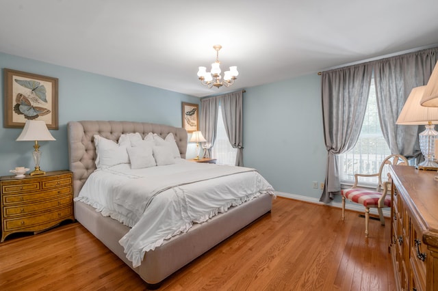 bedroom with light hardwood / wood-style floors and a chandelier